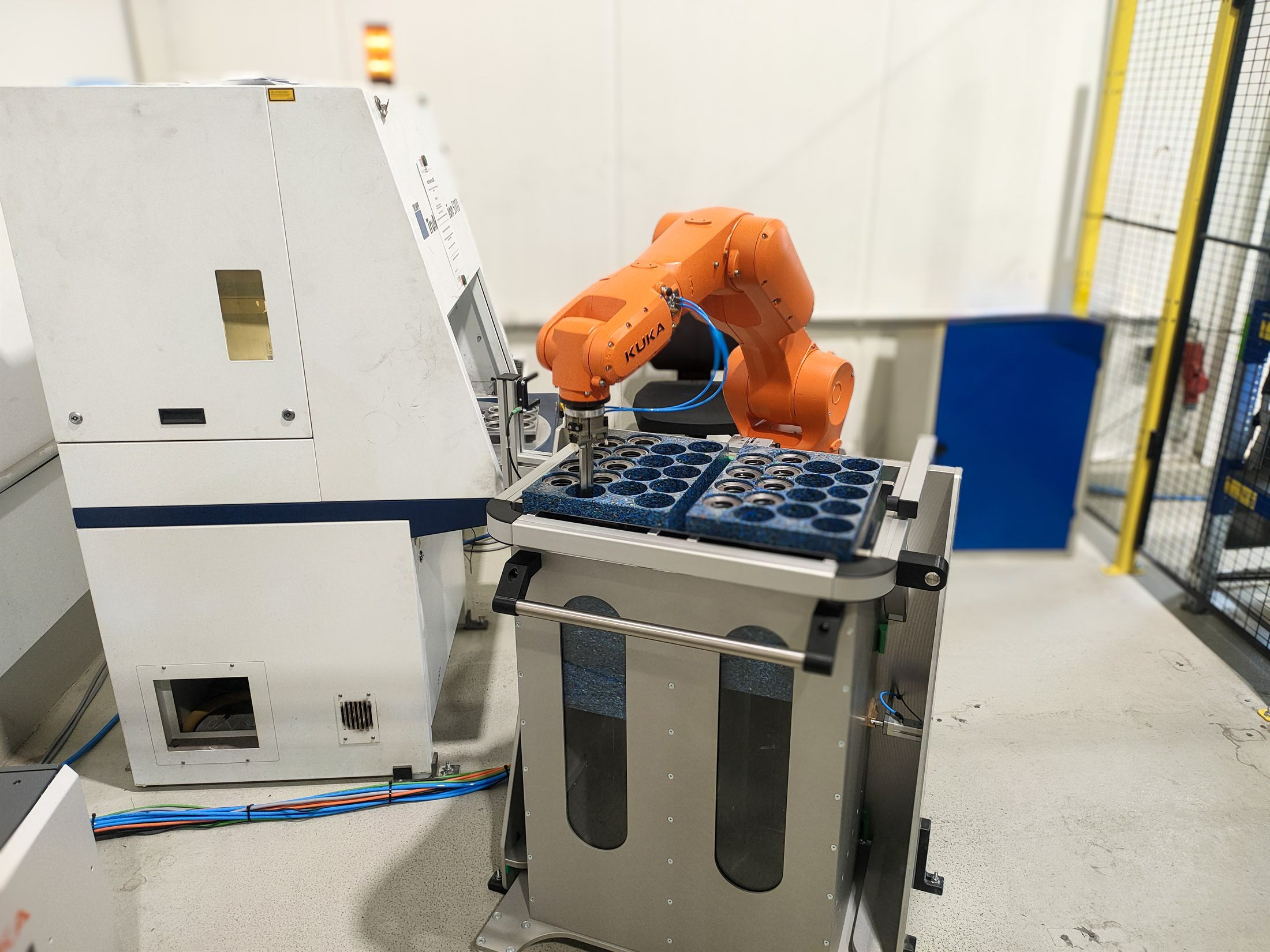 KUKA Roboter mit Trolley Feeder an einer Lasergravieranlage